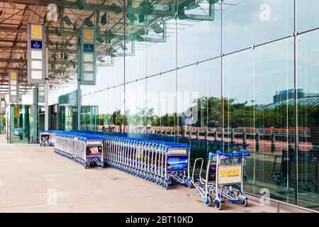 SINGAPUR - 24. MÄRZ 2015: Gepäckwagen säumen den leeren Eingang zum Abflughalle des Changi Airport Terminal 3. Stockfoto