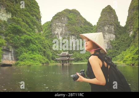Fotograf asiatische Frau, die Fotos mit slr Kamera professionelle Fotografie in Ninh Binh, Vietnam Stockfoto