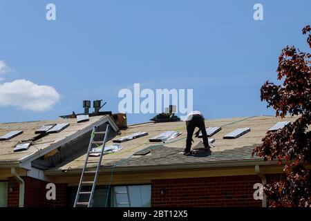 Dachreparatur, Arbeiter mit Ersatz grauen Fliesen Schindeln auf Haus angewendet Stockfoto