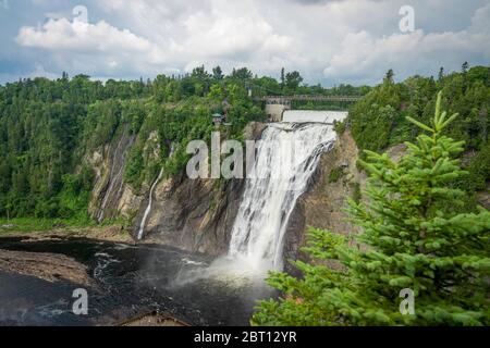 Wahnsinniger Blick auf den Montmorency Wasserfall mit einem Weihnachtsbaum im Vordergrund. Nur 10kms von Quebec City entfernt. Dieser Wasserfall ist erstaunlich, weil supe Stockfoto