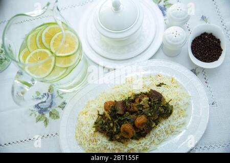 Reis in einem weißen Teller. In Scheiben geschnittene Zitrone. Eine Schüssel mit weißem Keramiksalz und Pfeffer. Shah Pilaf. Khan pilaf . Schwarzer Pfeffer in einem weißen Keramiktopf. Das ist ja so Stockfoto