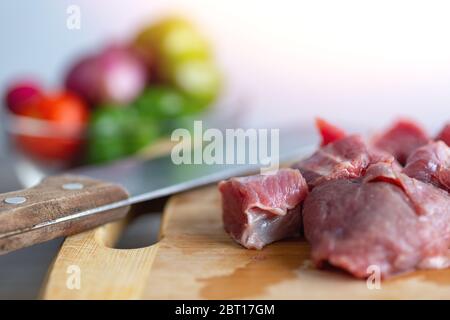 Nahaufnahme von Fleisch in Rindfleisch Eintopf Würfel Stücke auf Holzbrett geschnitten. Kochen Abendessen auf Küchentisch Konzept Stockfoto