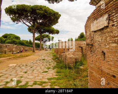 Ostia Antica, Italien - 12. Juli 2019: Blick auf den Decumanus Maximus in der antiken römischen Ausgrabungsstätte von Ostia Antica bei Rom. Stockfoto