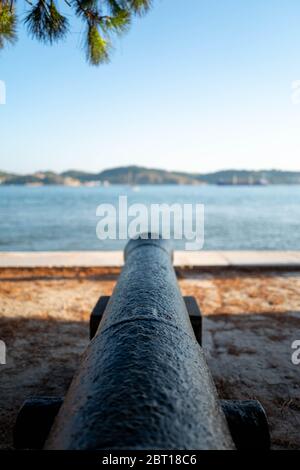 Europa, Portugal, Lissabon. Eine Kanone auf den Docks von Lissabon zeigt auf das Meer. Stockfoto