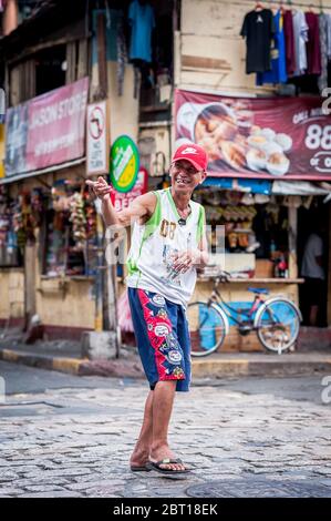 Ein glücklicher philippinischer Mann scherzt mit Freunden in der alten ummauerten Stadt Intramurous, Manila, den Philippinen. Stockfoto