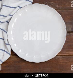 Weiße Platte und weiße Serviette auf Holztisch reinigen. Ansicht über dem Bild mit Kopierfläche, Modell Stockfoto