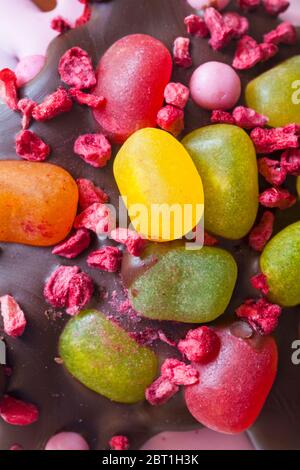 Gefriergetrocknete Himbeeren und Gelee-Bohnen Dekorationen auf dem fruchtigen Osterei der M&S-Ostersonntage Stockfoto