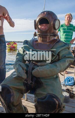 Tallinn, Estland - 18. Juli 2009: Ein Taucher im Tiefseeanzug sitzt auf einem Stuhl. Runder Helm mit mehreren Löchern und Glas. Vertikal. Stockfoto