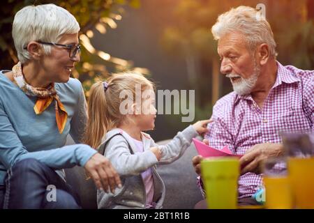 Glücklich lustige Familie.Großeltern spielen mit lächelnden Enkelin. Stockfoto