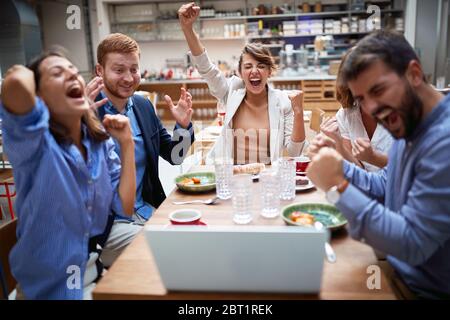 Gruppe von jungen Erwachsenen mit einem Videoanruf im Restaurant, Celcebrating. Technologie, Geschäftspartner, Kollegen online, Internet, Freunde, Stockfoto
