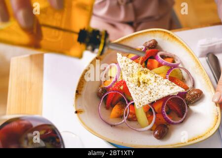 Weibliche Hand Gießen Olivenöl auf Käse Stockfoto