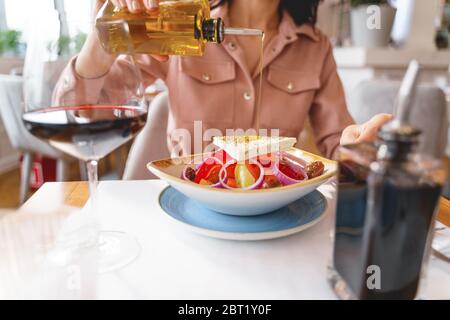 Junge Frau Hand gießen Olivenöl auf Käse Stockfoto