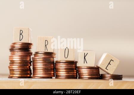 Holzwürfel mit dem Wort Broke und Pile von Münzen, Geldklettern Treppe, Geschäftskonzept Hintergrund Stockfoto