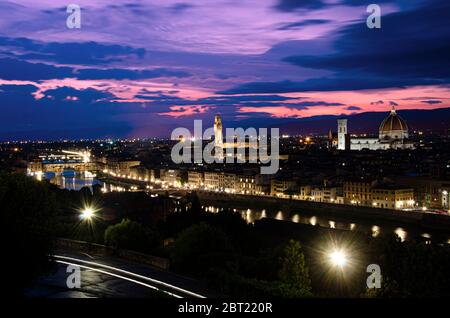 Nachtansicht von Florenz bei Sonnenuntergang vom Michelangelo Platz, Italien. Schöner lila und rosa Himmel mit Wolken über Florenz in der Nacht. Stockfoto