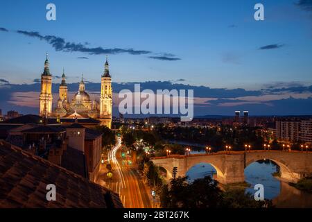 Basilika El Pilar und die römische Brücke über den Fluss Ebro. Blick in die Dämmerung. Zaragoza, Spanien. Stockfoto