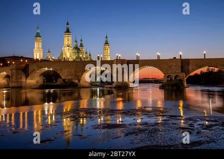 Basilika El Pilar und die römische Brücke über den Fluss Ebro. Blick in die Dämmerung. Zaragoza, Spanien. Stockfoto