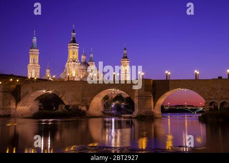 Basilika El Pilar und die römische Brücke über den Fluss Ebro. Blick in die Dämmerung. Zaragoza, Spanien. Stockfoto