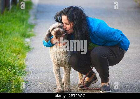 Frau umarmt Hund (Lagotto romagnolo) Stockfoto