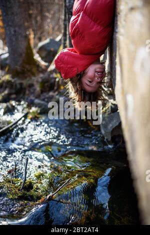 Junge, der kopfüber über dem Rand einer Brücke hängt, USA Stockfoto