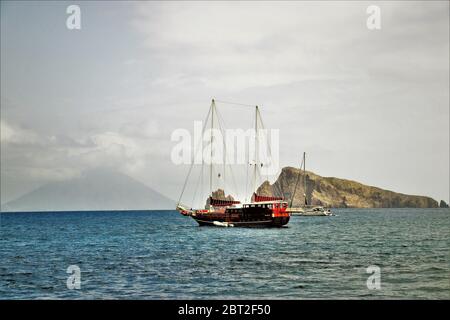 Segeln entlang der Äolischen Inseln in Sizilien, Italien, mit Blick auf den Vulkan Stromboli im Hintergrund. Stockfoto