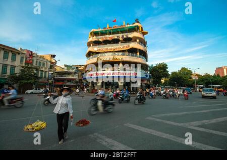 Frau trägt Korb auf Schulter in Hanoi, Vietnam Stockfoto