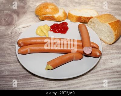 Würstchen mit Senf, Ketchup und rollt auf s Holztisch. Stockfoto