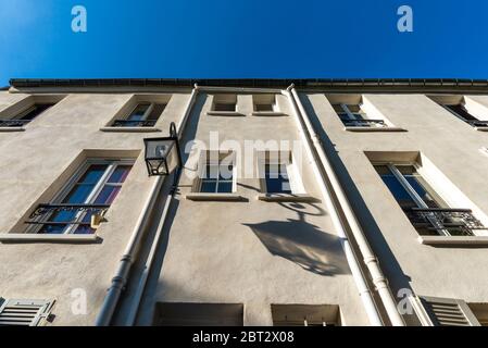 Niedrige Winkelansicht einer hellbeige Fassade mit Außenlaterne, die ihren eigenen Schatten wirft, Butte-aux-Cailles, Paris, Frankreich Stockfoto