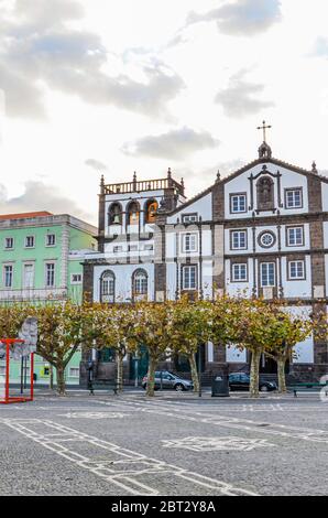 Ponta Delgada, Azoren, Portugal - 12. Januar 2020: Gepflasterter Platz im historischen Zentrum der portugiesischen Stadt. Traditionelle historische Häuser. Sonnenuntergang Himmel mit Wolken. Vertikales Foto. Stockfoto