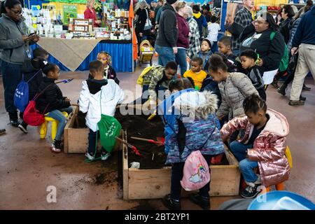 Harrisburg, PA / USA - 9. Januar 2020: Kleine Kinder spielen und graben im Dreck auf der Pennsylvania Farm Show. Stockfoto