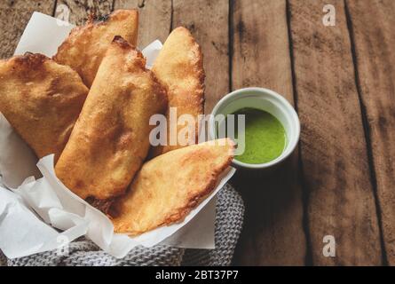VENEZOLANISCHE KOLUMBIANISCHE KÜCHE. Venezolanische Typicals Mais Empanadas mit Fleisch in Tonschüssel mit Avocado-Sauce, gebratene Empanadas, gefüllt mit Huhn und Mea Stockfoto