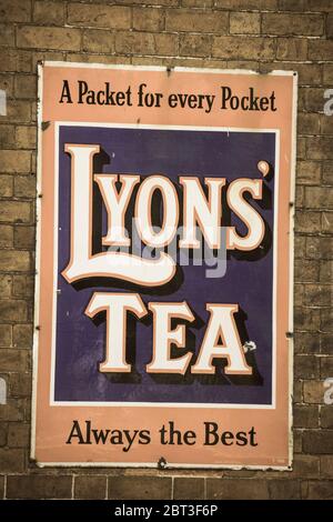 Isoliertes emailliertes Vintage-Schild, Schilder für British Lyon's Tea am Bahnhof des britischen Kulturerbes. Outdoor antike Vintage Werbung. Stockfoto