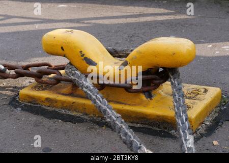 Gelbe Poller an der Hafenmauer zur Befestigung am Schiff. Stockfoto