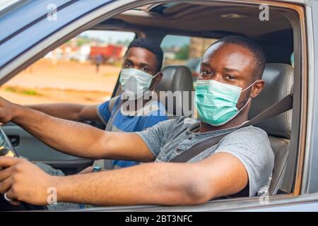 afrikanischer Fahrer und Beifahrer mit Gesichtsmasken Stockfoto