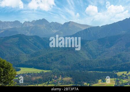 Hohe tatra Bergrücken. polen Reiseziel. Schöne Sommerlandschaft im Abendlicht. Sonniges Wetter mit flauschigen Wolken am blauen Himmel. Stockfoto