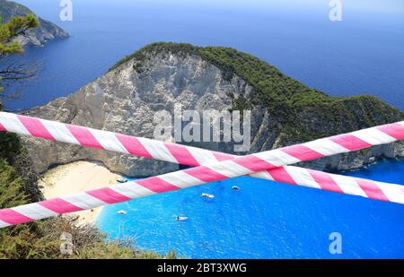 Rot und weiß Barriere Band über exotischen schönen Strand Hintergrund. Urlaubskonzept, verzögerte Reisen, keine Sommerpläne mehr und Isolation zu Hause aufgrund COVID-19 Corona-Virus Pandemie Ausbruch. Stockfoto