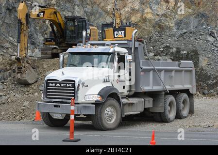 Ein MÜLLWAGEN der MARKE MACK von Hazelwoord Construction Services transportiert eine Ladung gebrochenes Gestein auf einer Entwicklungsstelle vor der McCallum Road im GRE Stockfoto