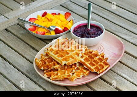 Teller mit frisch gebackenen Waffeln und frischem Beerenkompott zum Frühstück Stockfoto
