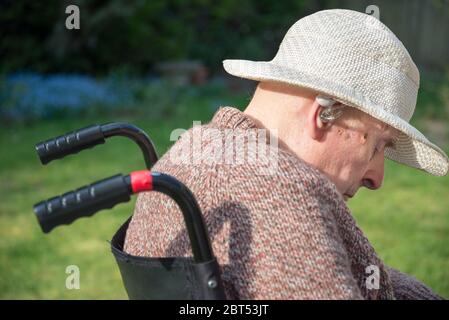 Auf seiner hinteren Gartenterrasse an einem warmen englischen Frühlingsnachmittag, sich von Kopfverletzungen, Hirnschäden und dem Umgang mit Demenz zu erholen. Stockfoto