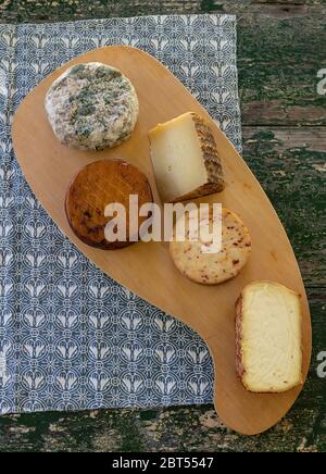 Blick von oben auf verschiedene Käsesorten auf einem rustikalen Holzbrett. Blauschimmelkäse, Käse, Manchego, geräucherter Käse. Stockfoto