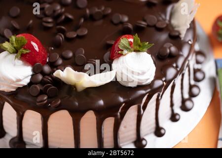 Vanillekuchen mit heißer Schokolade Belag mit glasierten Erdbeere. Schokoladenkuchen mit Schokolade Ganache Stock Foto Stockfoto