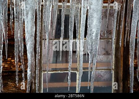 MT00526-00...MONTANA - Eiszapfen, die im Winter in der Geisterstadt Garnett vom Dach der McDonald Cabin hängen. Stockfoto