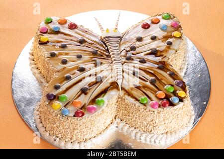 Butterfly geformte Vanillekäse Kuchen mit farbigen Toffee Belag mit Glasierte Mokka-Creme auf silbernem Boden Stockfoto