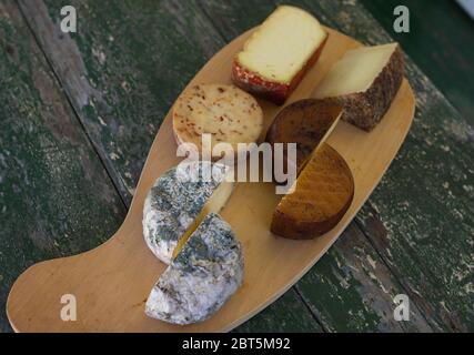 Blick von oben auf verschiedene Käsesorten auf einem rustikalen Holzbrett. Blauschimmelkäse, Käse, Manchego, geräucherter Käse. Stockfoto