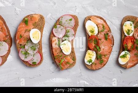 Wachteleier Sandwiches auf grauer Tafel. Flache Lay Zusammensetzung. Stockfoto