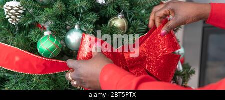 Afrikanisch-amerikanische Nigerianerin Weihnachtsbaum mit Dekorationen für weihnachten dekorieren - Banner Panorama Stockfoto