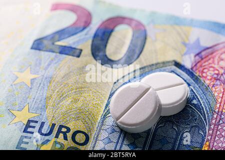 Zwei generische weiße Tabletten auf einem 20 Euro-Schein in einem Konzept der Zahlung von medizinischen Gebühren und Kosten für die Gesundheitsversorgung Stockfoto