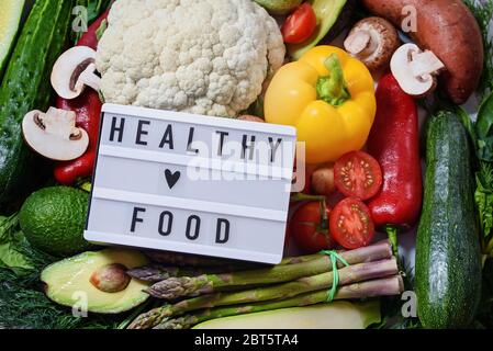 Verschiedene Gemüse Hintergrund. Gesundes Essen Konzept. Flaches Lay. Frisches Gemüse, Kräuter und Gewürze. Rohes Öko Gemüse Lieferung. Text in englisch Gesundheit Stockfoto