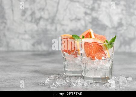 Kaltes Getränk mit Eis und Minzblättern. Cocktail Tonic Grapefruit garniert Stockfoto