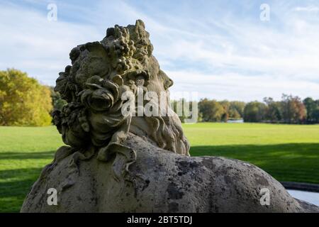Neptun-Statue in einem französischen Landschlosspark. Foto von hinten, das den oberen Rücken und Kopf zeigt und im Spätsommer in Frankreich aufgenommen wurde Stockfoto