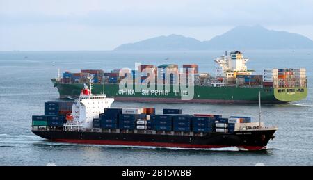 Container-Schiffe transportieren Fracht in Hong Kong vom Festland China, Victoria Harbour, Hong Kong, China. Stockfoto